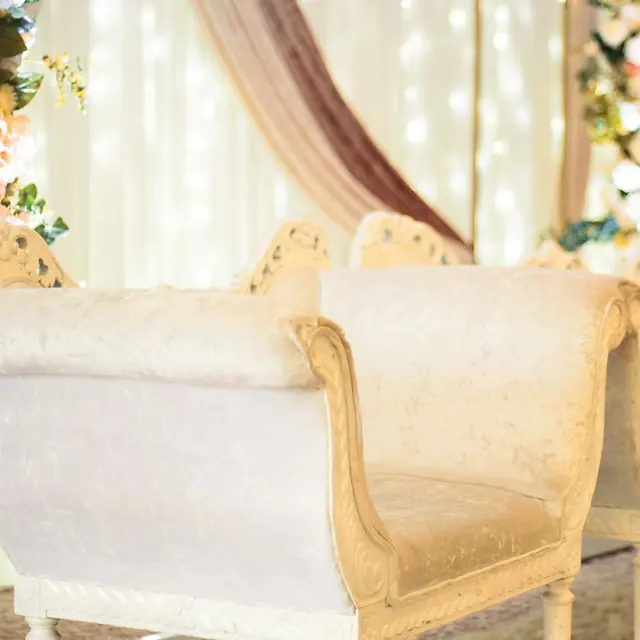 Ivory benches beneath a soft blush drape
