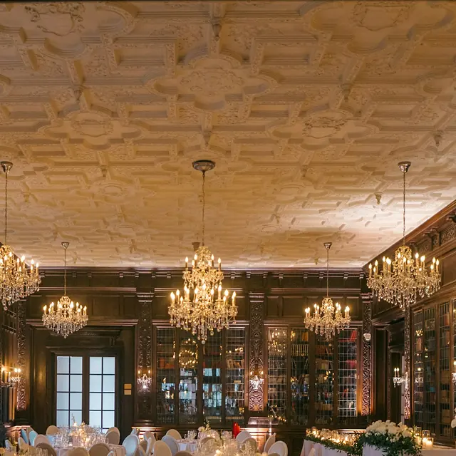 Crystal chandeliers over a wood-paneled ballroom